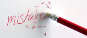 red pencil erasing the word mistakes