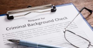 criminal background check form with pen and glasses on top