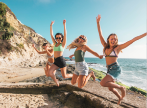 four girls in front of water